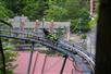 A man comes around the corner on the coaster with Gatlinburg hotels in the background