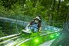 A man in a hat and overalls smiles on the Moonshine Mountain Coaster in Gatlinburg, TN, USA