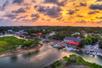 Aerial view of the home and businesses on the water with a bright orange sunset overhead in Myrtle Beach.