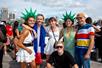 A group of tourists posing together for a photo with two of the tourists wearing Statue of Liberty inspired hats.