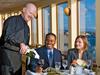 Close up of a couple being served wine by a waiter at Newport Beach Dining Cruises in San Diego, California, USA