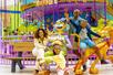 Family posing with Rugrats characters on a bench in front of their ride at Nickelodeon Universe at American Dream in Newark, New Jersey, USA.