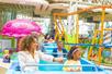 A family on a roller coaster with a giant pink jellyfish behind them at Nickelodeon Universe at American Dream in Newark, New Jersey, USA.