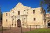 The front of The Alamo with the sun shining on it in San Antonio.