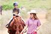 A woman leading a young boy on a horse at Gunstock Ranch in Oahu, Hawaii.