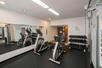 Fitness room with cardio equipment and weights.