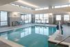 An indoor swimming with chairs along the side and several windows letting in natural light at theResidence Inn by Marriott Columbus Airport.