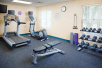 Fitness center with plenty of gym equipment.