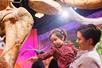 Adult holding a toddler who is reaching out to touch a mammoth bone on display at Ripley's Believe It or Not!.