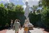 People looking up at a large statue of David on a sunny day with bushes around it in St. Augustine.