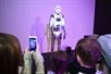 An audience watches a robot on stage as the audience member to the left snaps a photo of the robot with a smartphone at Roboland in Orlando, Florida.