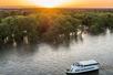 Aerial view of the Sacramento River: Alive After Five Cruise with the bright orange sun setting in the distance.