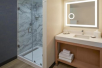 Private bathroom with a glass-enclosed shower, well lighted vanity area, and fresh towels.