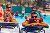 A mother and father laying out with their children sitting on them at Schlitterbahn New Braunfels in San Antonio, Texas.