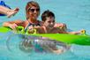 A mother and son floating in a tube in the water and smiling at Schlitterbahn New Braunfels in San Antonio, Texas.