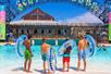 Four young guests holding their tubes and looking into the wave pool at Schlitterbahn New Braunfels in San Antonio.