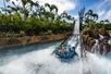 People riding Infinity Falls and splashing into the water on a sunny day at SeaWorld in Orlando, Florida.
