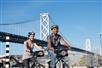 Couple biking near the Bay Bridge on the Self-Guided Bike Tour in San Francisco