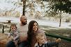 A family of four with two young kids laughing and having white on a hayride on a fall day at Shepherd’s Pumpkin Fest.