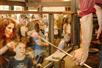 A family watching a man blow glass at Silver Dollar City in Branson, Missouri.