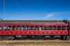 An old red train car saying "California Western" parked with a bright blue sky above it with Skunk Train in San Francisco, California, USA.