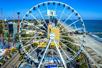Aerial view of the Myrtle Beach SkyWheel on a bright and sunny day with the city on the left and the beach and ocean on the right.