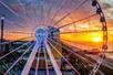 Aerial close up of the Myrtle Beach SkyWheel with a bright orange sun setting behind it.