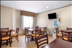 Breakfast dining area with water station and flat-screen TV.