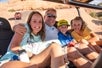 A family posing for the camera in the back of the Hummer while going up a steep hill on the Slickrock Safari Hummer Adventure Tour in Moab Utah.