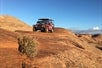 A beautiful view of the petrified sand dunes behind the Hummer H1 as it makes it way over some hills on the Slickrock Safari Hummer Adventure Tour in Moab Utah.
