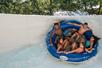 Five teenagers in a large blue tube going down a large white waterslide at Splish Splash Water Park.