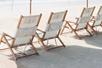 Four striped beach chairs in a row on a beach in St. Augustine, Florida.