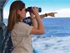 A guest uses binoculars to spot whales