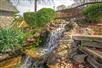 Waterfall and a garden pond and wooden walkway and gathering area.