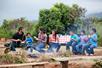 A family sitting and eating in front of a fire at Gunstock Ranch Horseback Rides in Oahu - Kahuku, HI