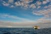 A super-raft on a whale watching tour with dark water around them and clouds over head near Kailua-Kona, Hawaii.