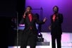 Two men in red and black suits singing into microphones on stage at The Best of Motown and More in Branson, Missouri.