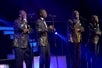 Four men in gold suits singing into microphones on stage at The Best of Motown and More in Branson, Missouri.