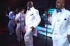 Four men in white suits and blue bow ties singing into microphones on stage at The Best of Motown and More in Branson, Missouri.