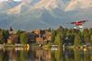 View of Lakefront Anchorage on the shore of Lake Spenard, a sea plane, and the majestic Chugach Mountains behind.