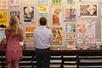 A man and woman standing and looking at a wall of posters at the Country Music Hall of Fame and Museum - Hatch Show Print.