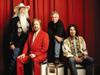 The Oak Ridge Boys pose with a red curtain in the background