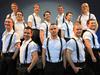 Irish dancers wearing white shirts with black suspenders