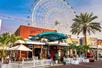 The front exterior of Sloppy Joe's Orlando with The Wheel at ICON Park in the background at sunset in Orlando.