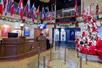The lobby and ticket desk of the Titanic Museum with flags hanging above the desk along with garland and a large Christmas tree to the right.