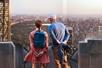 A man and woman facing away from the camera looking over the city at the Top of the Rock Observation Deck.