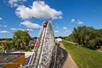 Wide shot of a coaster car going downhill on the Renegade coaster on a sunny day at Valleyfair in Bloomington, Minnesota.