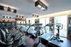 A fitness center with two rows of cardio equipment in front of a wall of large windows showing the city of Las Vegas.