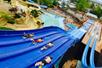 Four teenage boys going down a water slide on their stomachs at White Water in Branson, Missouri.