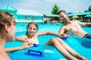 A family floating in the wave pool in tubes on a sunny day at White Water in Branson, Missouri.